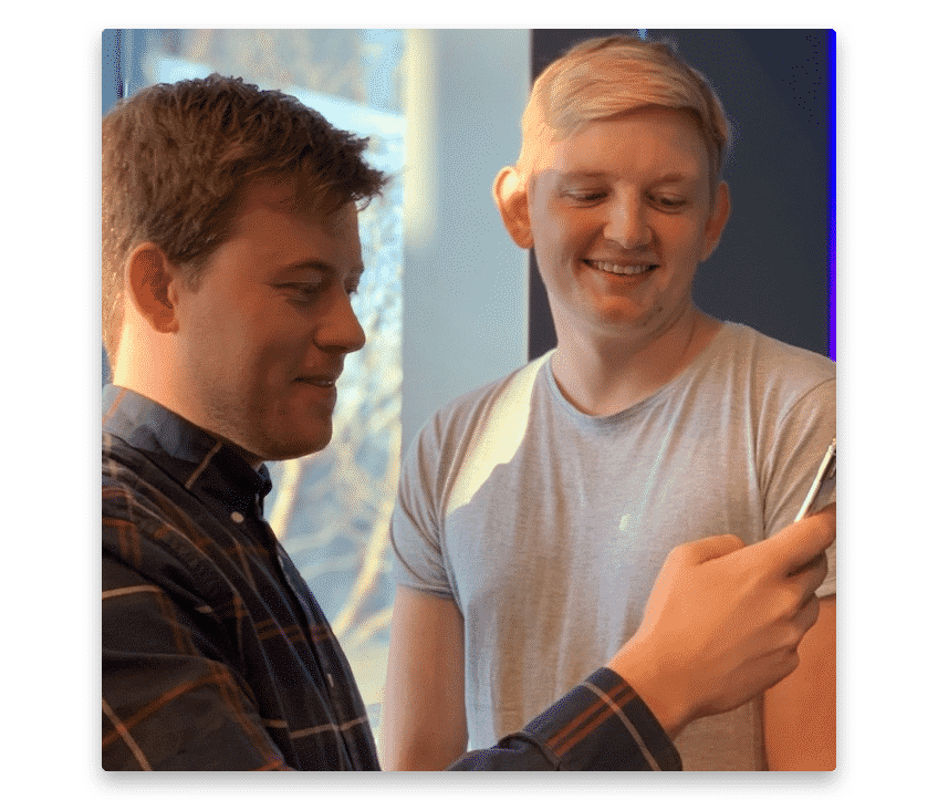 Two guys happily looking at a phone